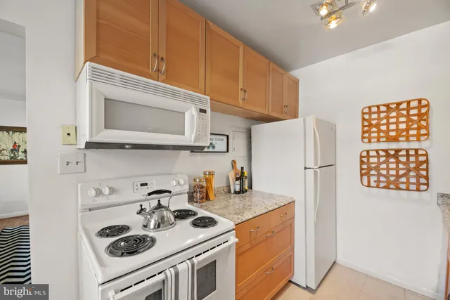 a kitchen with stainless steel appliances granite countertop a refrigerator a stove a sink and a microwave