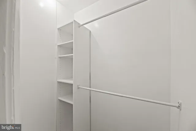 a view of walk in closet with empty racks