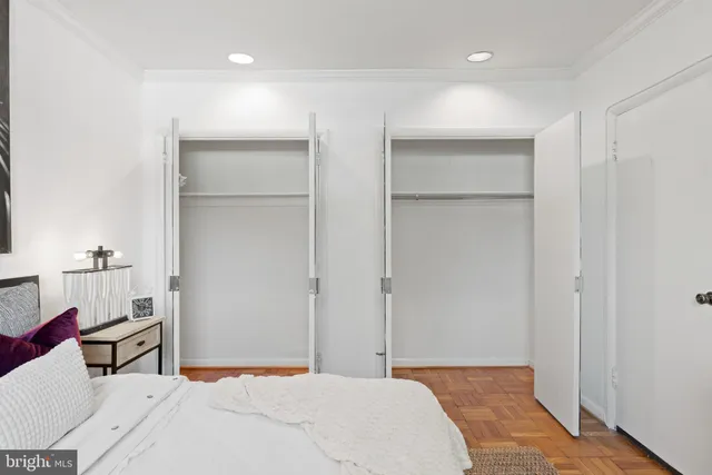 a bedroom with a bed and a lamp on the dresser