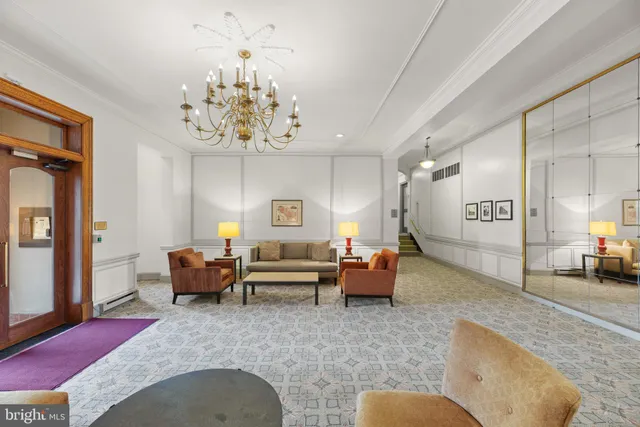a living room with furniture chandelier and a rug