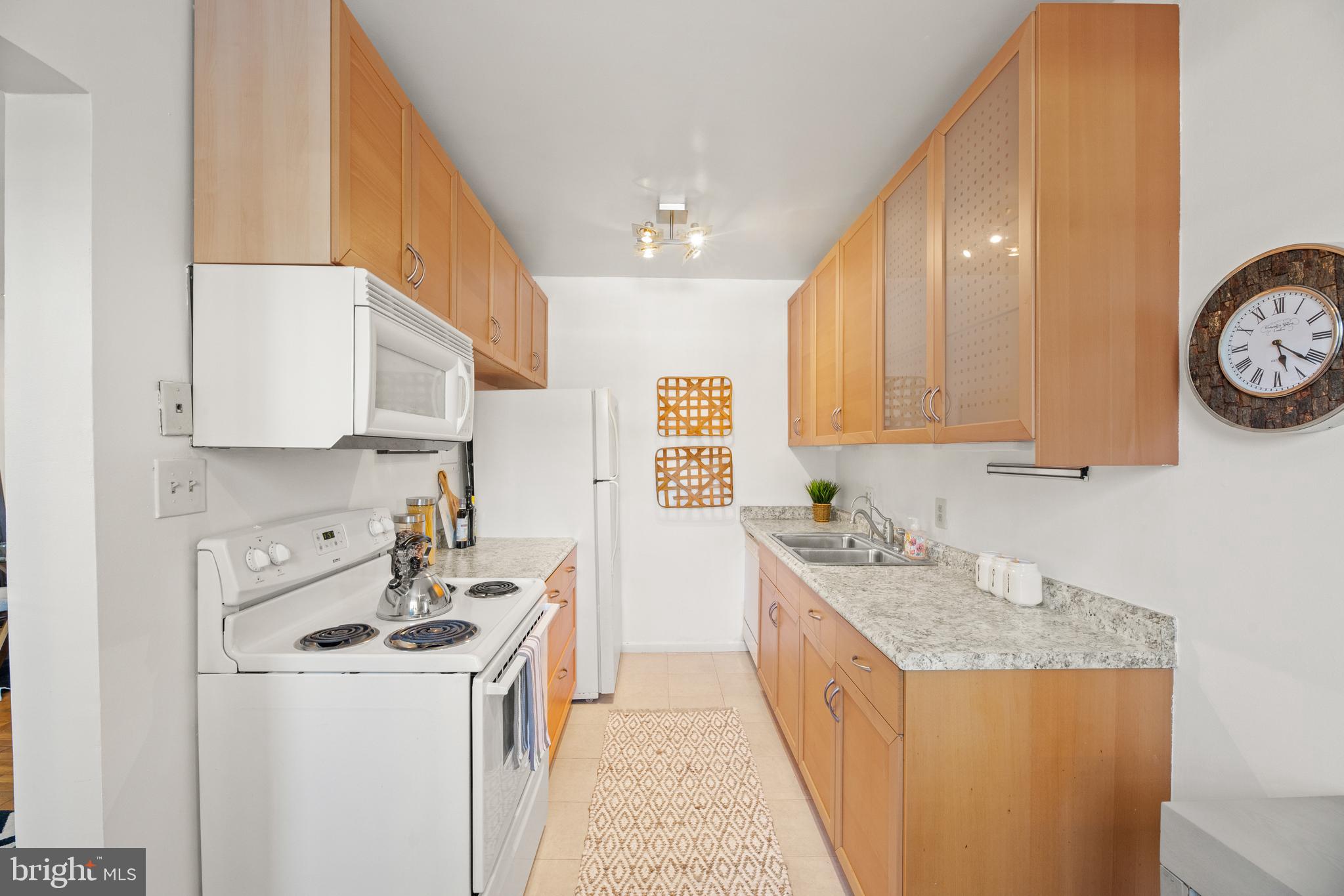 3051 Idaho Avenue Northwest, Unit 119 Washington, DC 20016 - Photo 10 of 36 a kitchen with a sink a stove and cabinets