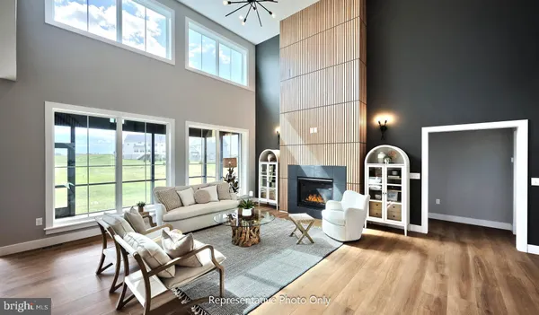 a living room with furniture kitchen view and a chandelier