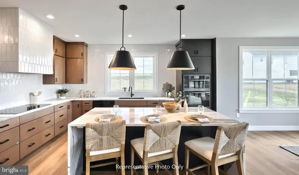 a kitchen with kitchen island a stove a refrigerator and a wooden floor