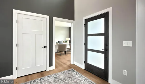 a view of a hallway with wooden floor and furniture