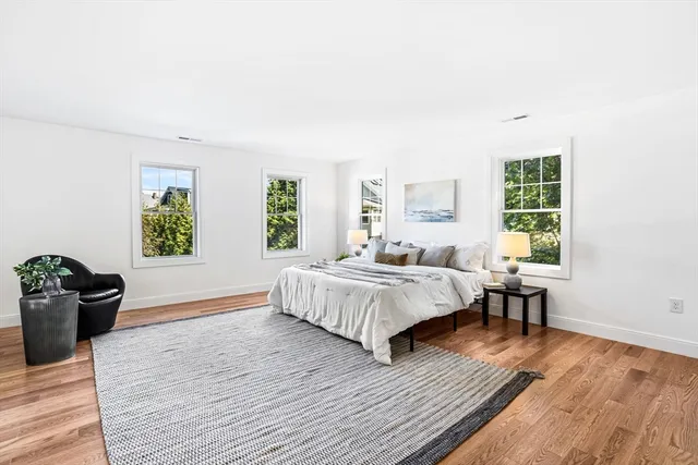 a spacious bedroom with a bed and wooden floor