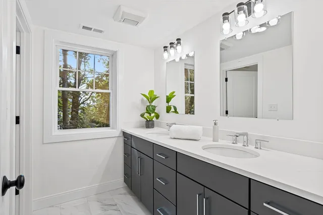 a bathroom with a double vanity sink and a mirror