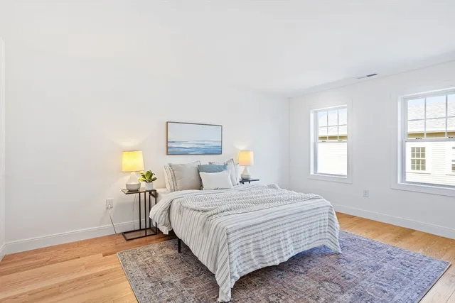 a bedroom with a bed lamp on table and a window