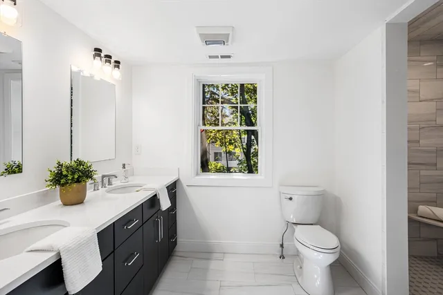 a bathroom with a sink toilet and window