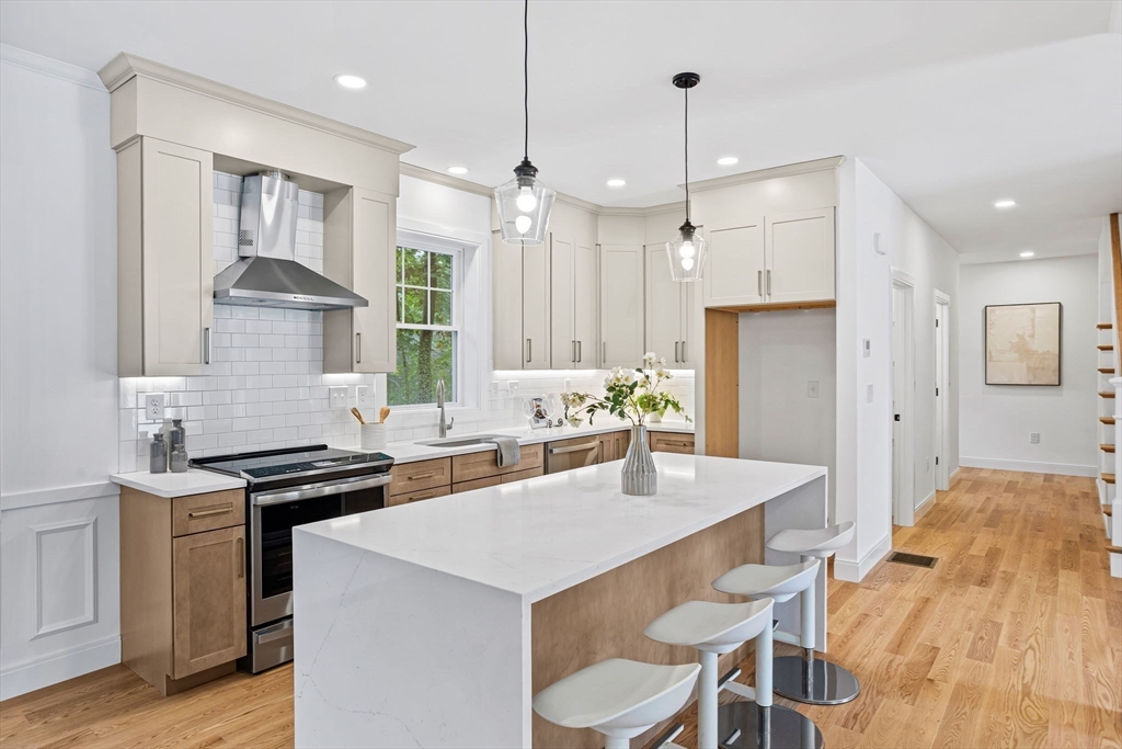 75 Franklin Street, Unit 2 Arlington, MA 02474 - Photo 7 of 38 a kitchen with stainless steel appliances kitchen island a table and chairs in it