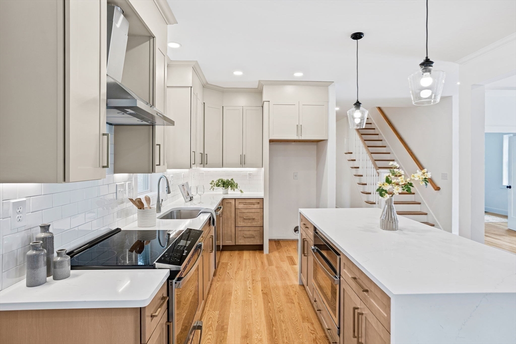 75 Franklin Street, Unit 2 Arlington, MA 02474 - Photo 8 of 38 a kitchen with stainless steel appliances kitchen island granite countertop a sink a stove and a wooden floors
