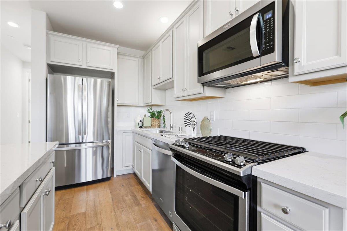 1910 Joshua Tree Circle Milpitas, CA 95035 - Photo 8 of 43 a kitchen with stainless steel appliances white cabinets and a stove top oven