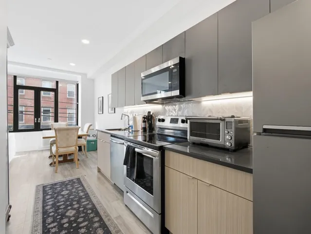 a kitchen with stainless steel appliances a stove microwave and sink