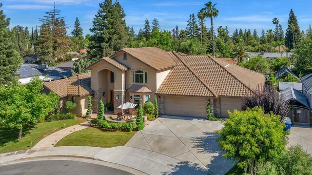 a front view of a house with a yard and trees