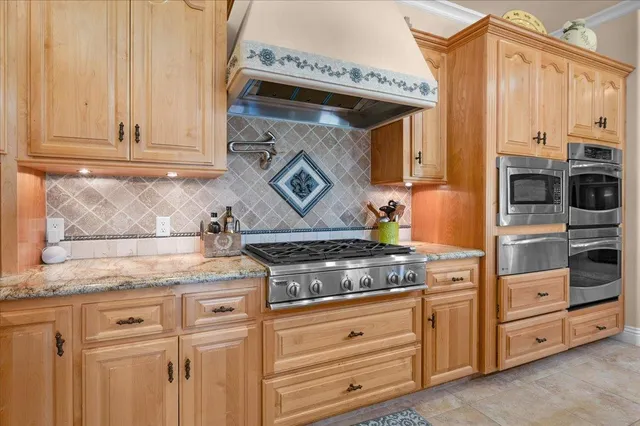 a kitchen with granite countertop cabinets stainless steel appliances and a sink