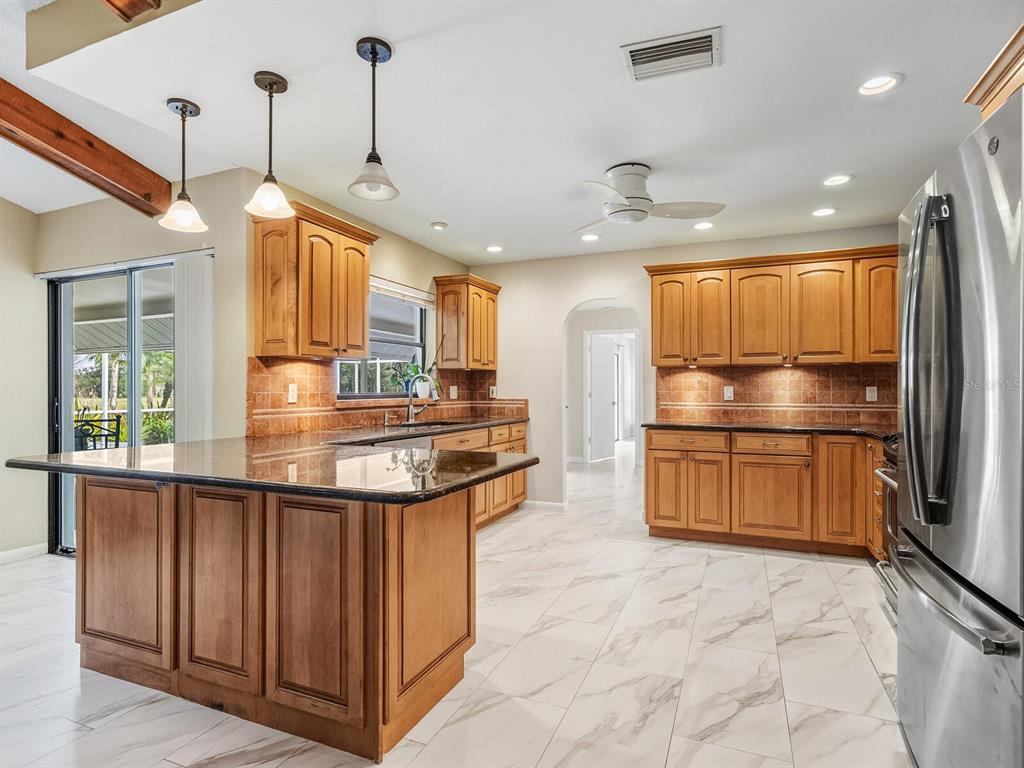 4725 Greencroft Road Sarasota, FL 34235 - Photo 5 of 41 a kitchen with stainless steel appliances granite countertop a stove and a refrigerator