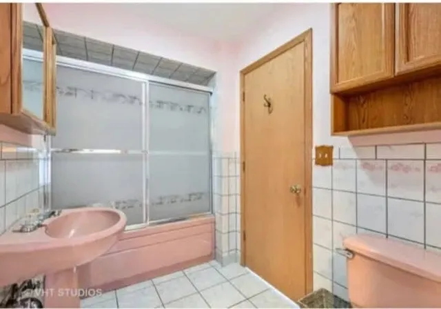 a bathroom with a granite countertop sink a toilet and shower