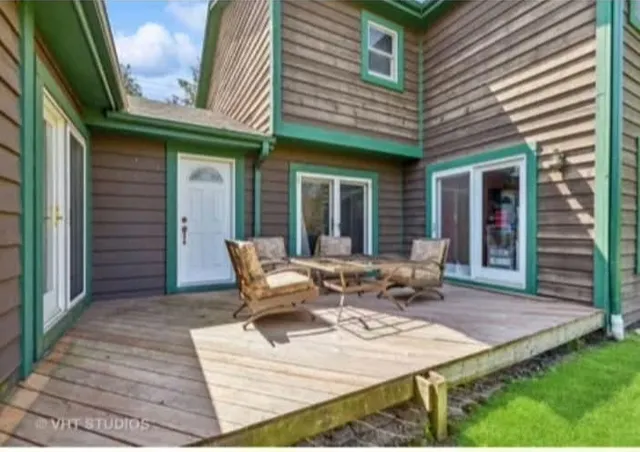 a view of a patio with table and chairs and wooden fence