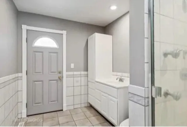 a bathroom with a double vanity sink a mirror and a bathtub