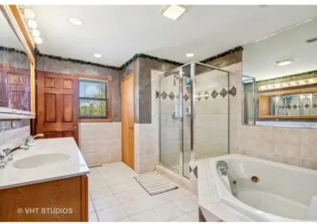 a bathroom with a tub sink and shower