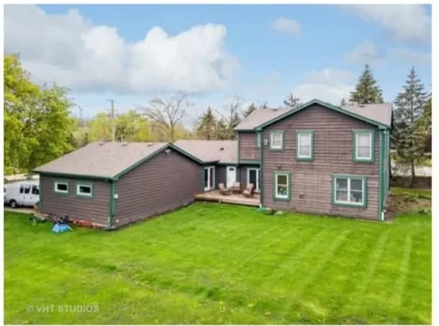 a view of a house with a yard and sitting area