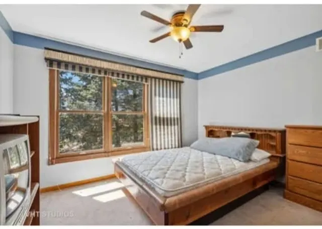 a bedroom with a bed and a large window with outer view