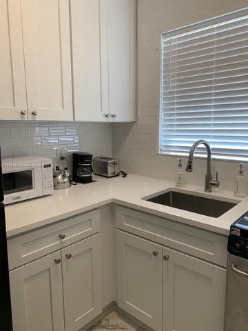 a kitchen with white cabinets and white appliances