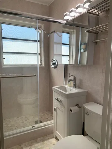 a bathroom with a sink a toilet and shower