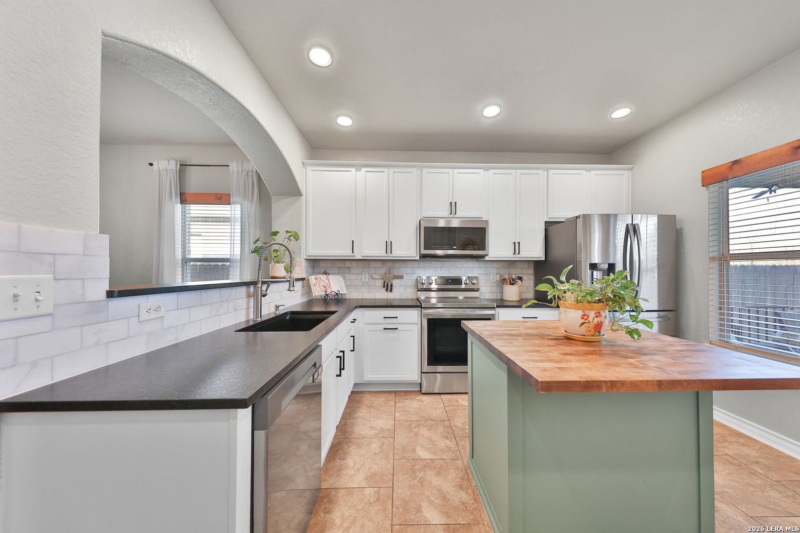 10414 Pecne Path Helotes, TX 78023 - Photo 17 of 42 a kitchen with kitchen island granite countertop a sink a counter top space appliances and cabinets