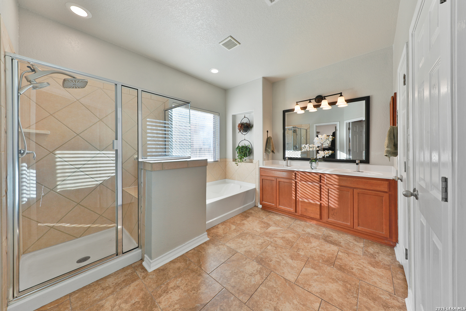 10414 Pecne Path Helotes, TX 78023 - Photo 28 of 42 a large bathroom with a glass door shower and mirror