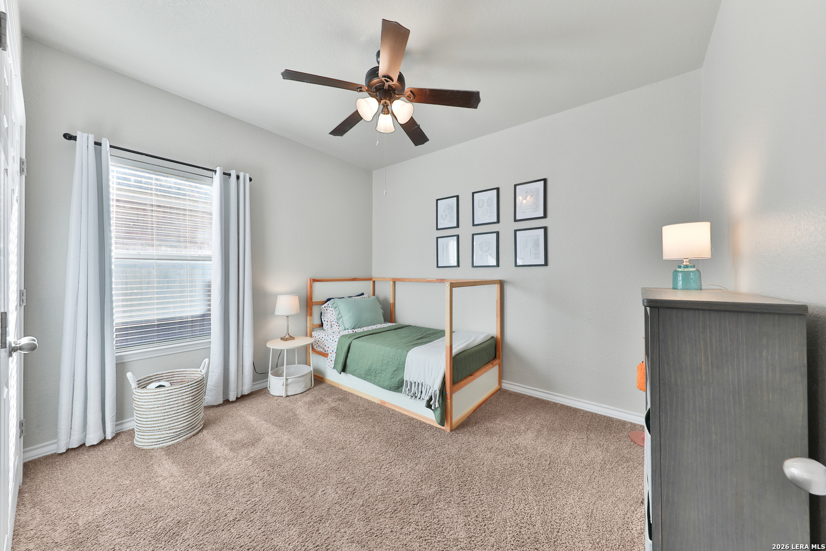 10414 Pecne Path Helotes, TX 78023 - Photo 31 of 42 a spacious bedroom with a bed and a chandelier