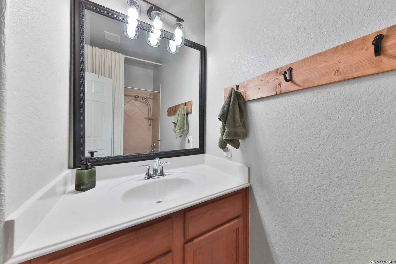 10414 Pecne Path Helotes, TX 78023 - Photo 33 of 42 a bathroom with a sink and a mirror