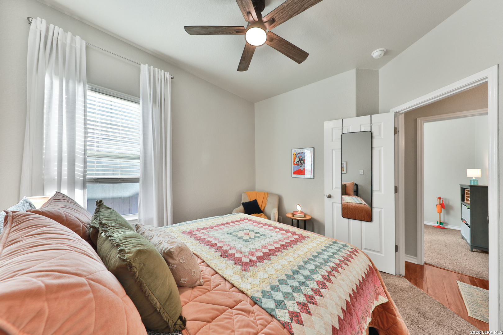 10414 Pecne Path Helotes, TX 78023 - Photo 35 of 42 a bedroom with a large bed and a chandelier