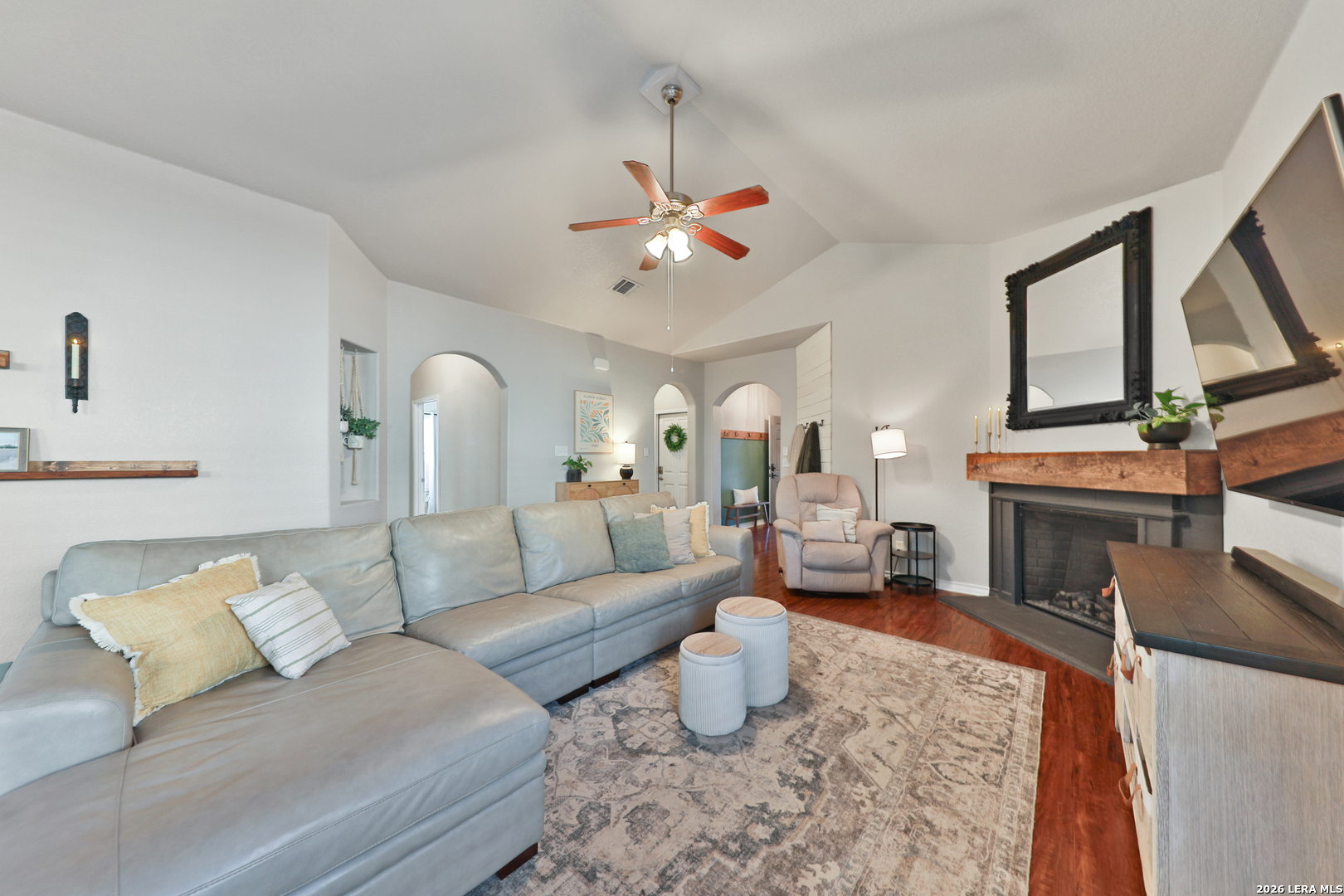 10414 Pecne Path Helotes, TX 78023 - Photo 7 of 42 a living room with furniture a fireplace and a chandelier