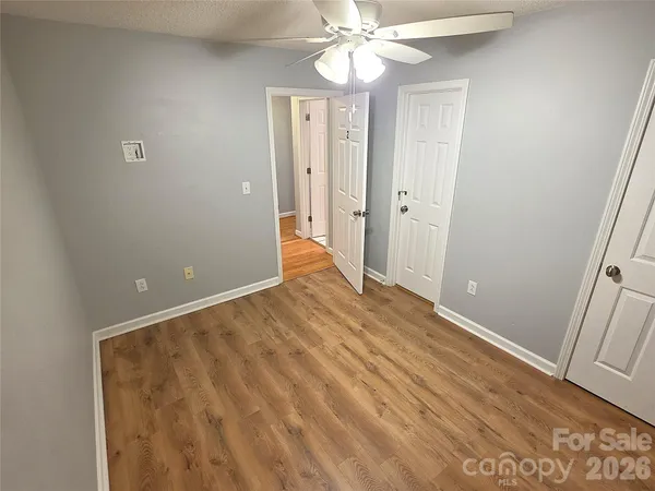 a view of a hallway with a chandelier fan and wooden floor