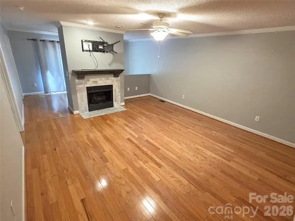 a view of empty room with wooden floor and fireplace