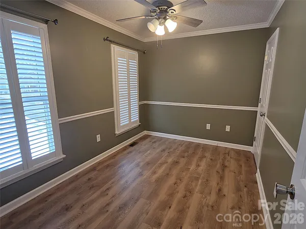 an empty room with a chandelier fan