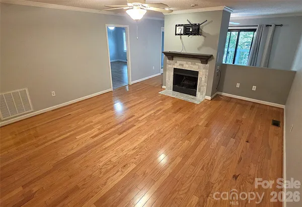 wooden floor fireplace and natural light in empty room