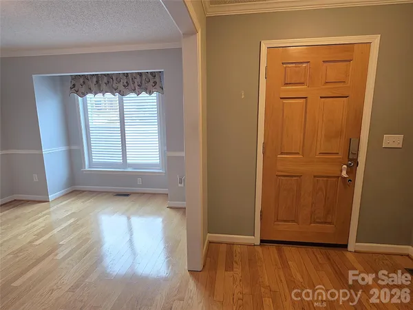 an empty room with wooden floor closet and windows