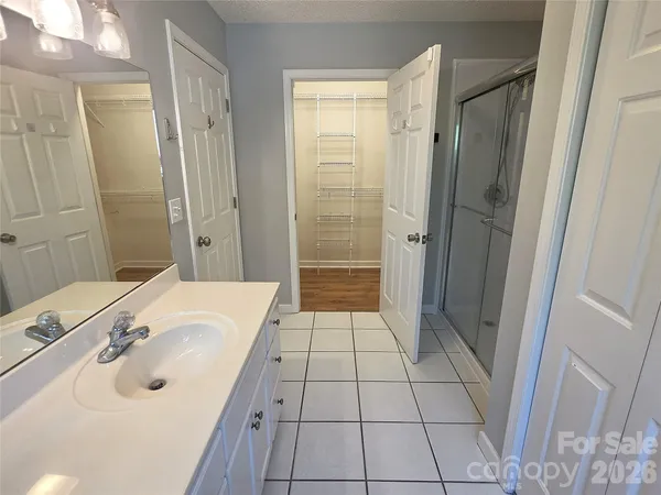 a bathroom with a sink shower and a mirror