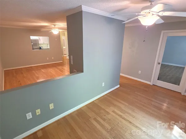 a view of an empty room with window and wooden floor