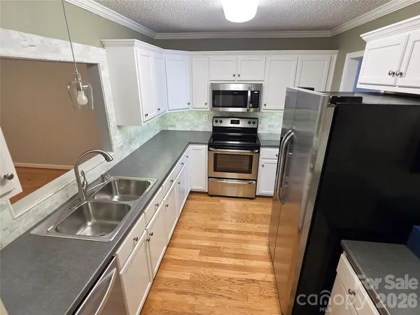 a kitchen with granite countertop a refrigerator and a sink