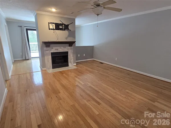 a view of empty room with wooden floor and fireplace