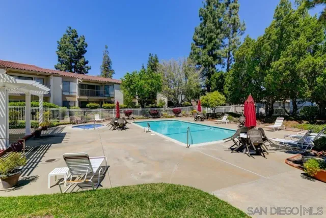 a view of a swimming pool with lounge chairs in patio