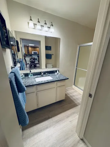 a bathroom with a granite countertop sink and a mirror