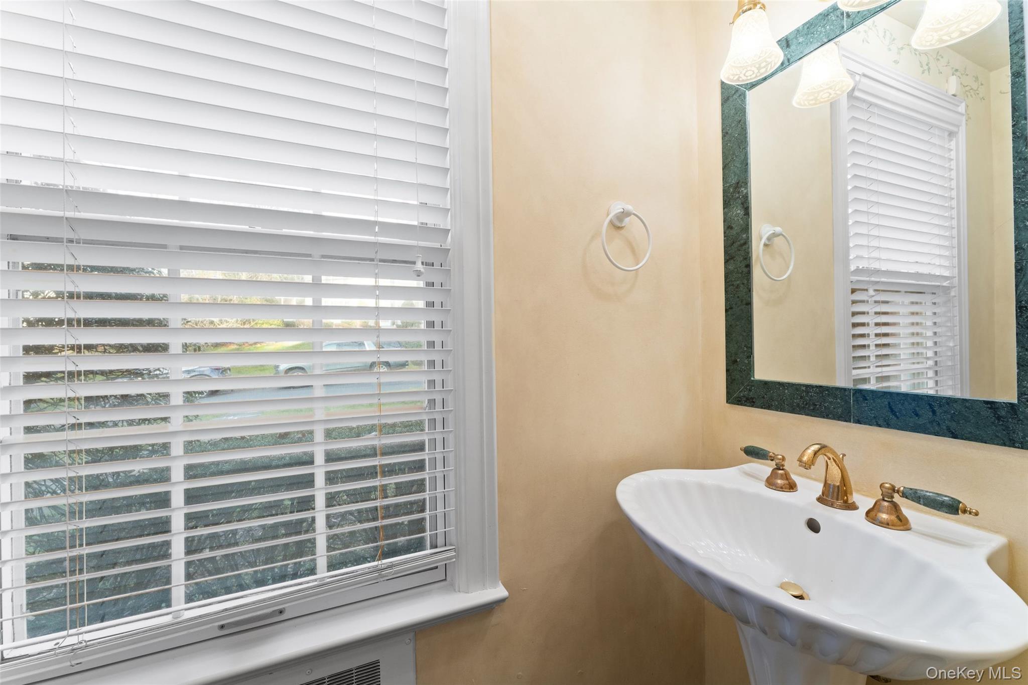 24 Olmsted Road Scarsdale, NY 10583 - Photo 15 of 39 a bathroom with a sink a mirror and a window