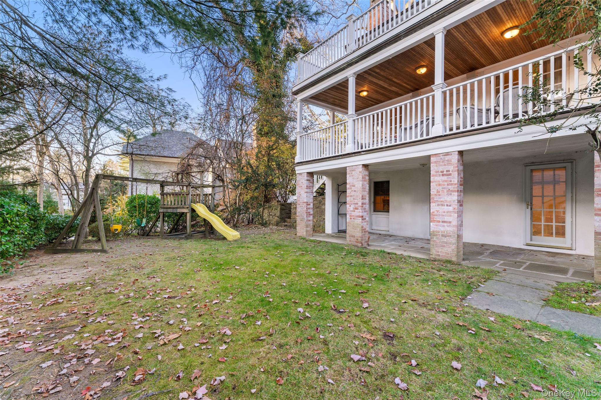 24 Olmsted Road Scarsdale, NY 10583 - Photo 31 of 39 a backyard of a house with table and chairs