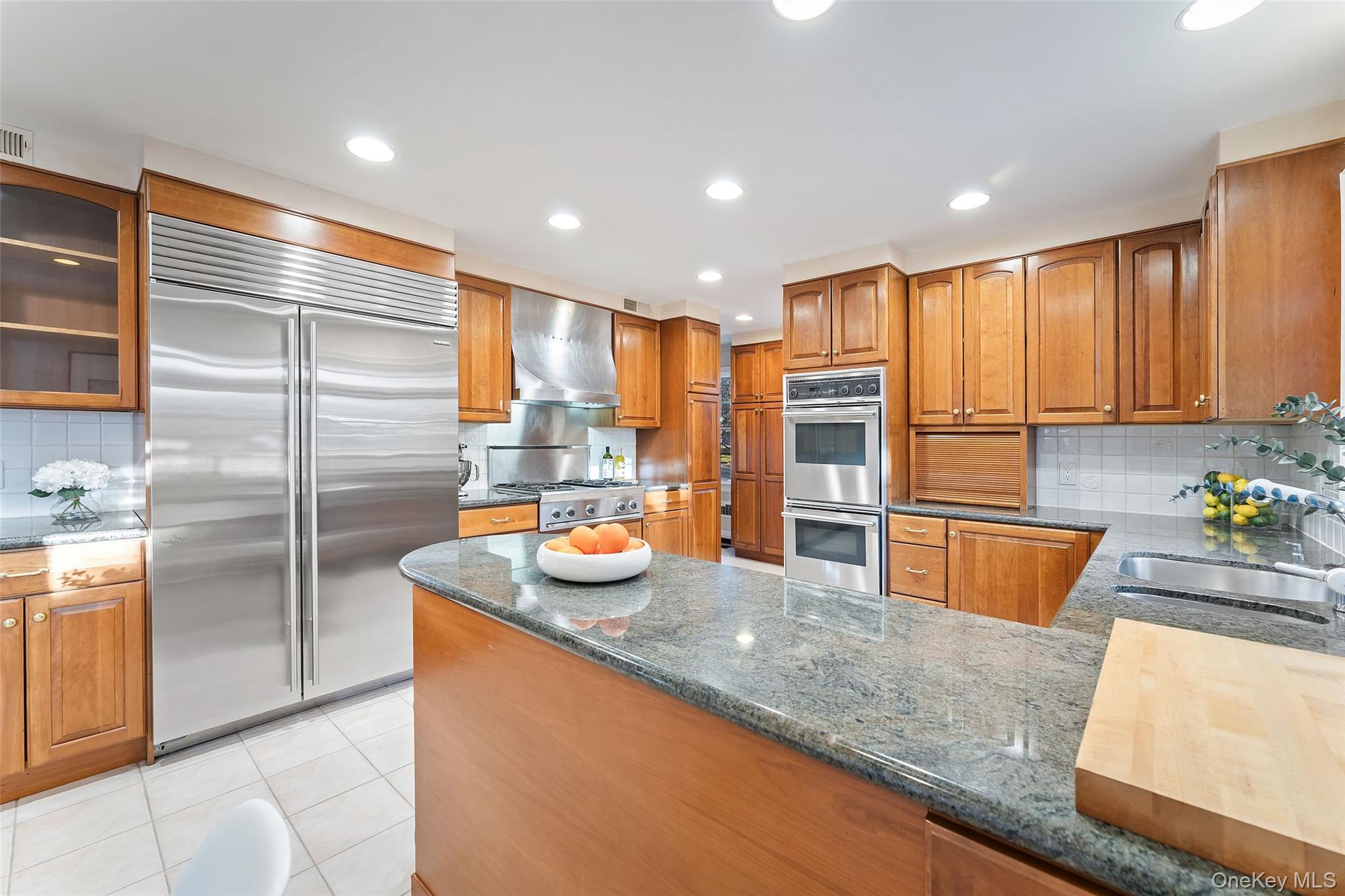 24 Olmsted Road Scarsdale, NY 10583 - Photo 10 of 39 a kitchen with stainless steel appliances granite countertop a sink refrigerator and cabinets
