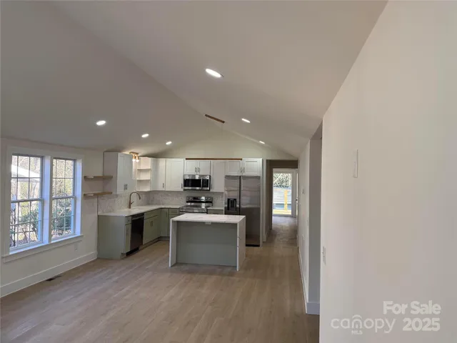 a kitchen with a sink cabinets and wooden floor