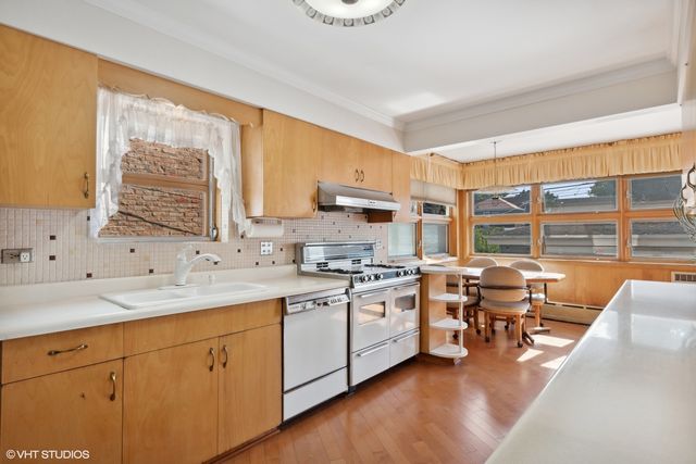 a kitchen with stainless steel appliances granite countertop a sink stove and cabinets