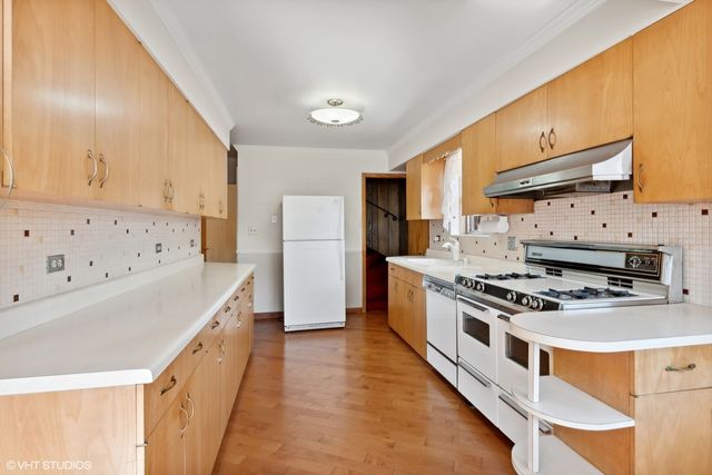 a kitchen with stainless steel appliances a stove a sink and a refrigerator